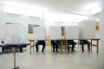 Voters on election day. Citizens casting their votes inside voting booths. Men and Women vote....