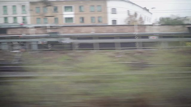 Window view of a train in london with a grey and cloudy weather and an ugly urban view.