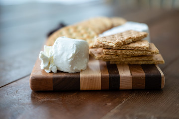 Fototapeta na wymiar Cheese and crackers on small board