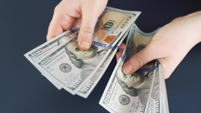 Close up of counting money. Nominal of 100 usa dollar notes counting. Business bills money. Tax day or getting a paycheck for work. 4k slow motion footage.