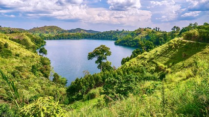 The lush, green, fertile landscape surrounding Lake Nyinambuga, an ancient volcanic caldera filled...