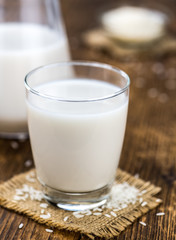 Vintage wooden table with Rice Milk (selective focus; close-up shot)