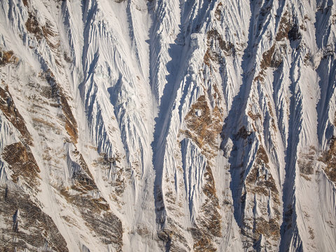 Aerial abstract view of jagged snow formations and steep ridges on a mountain face in the Himalayas, Nepal.