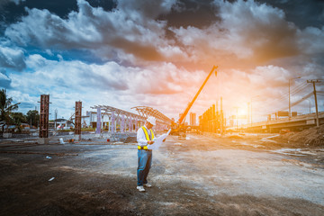 Fototapeta premium A senior engineer under inspection and checking construction process railway and checking work on railroad station platform .Engineer wearing safety uniform and safety helmet in work.