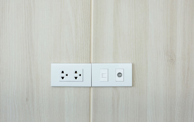 Plug socket on wooden wall.