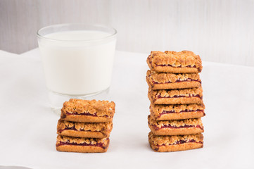 Freshly baked homemade cookies with jam in stack with milk in glass. Balanced nutrition, proteins and carbohydrates, cereals