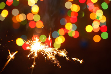 beautiful sparklers on the background of a garland. beautiful holiday card for the New Year.