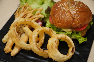 American burger with fried onions on a black plate