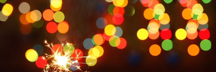 beautiful sparklers on the background of a garland. beautiful banner for the New Year.