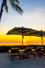 umbrella and chair around outdoor swimming pool in hotel resort for holiday vacation travel background