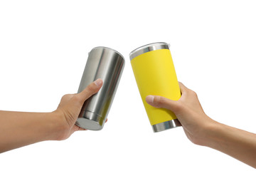 Two hand holding silver and yellow thermos mug,Clinking mug,Isolated on white background.