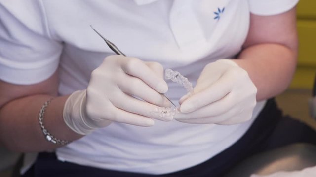  close-up view of an orthodontist handling an invisalign aligner
