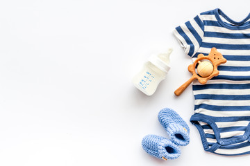 Baby background - blue color. Clothes and accessories for newborn boy on white table top-down frame...