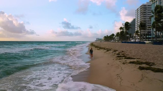 4K Fort Lauderdale By The Sea Attractive Woman Walks on Beach at Sunrise Aerial