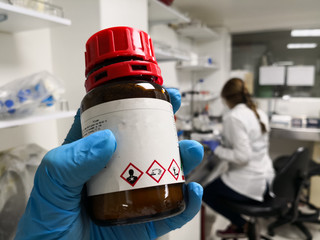 Amber bottle for protection of a hazardous chemical with GHS symbols that indicate toxicity,...