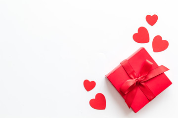 Gift to a sweetheart on Valentine's Day. Red present box near hearts on white background top-down copy space
