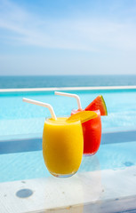 mango smoothie and watermelon smoothie with swimming pool and sea beach background