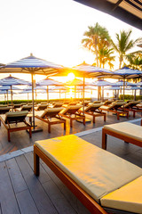Umbrella and chair sofa around outdoor swimming pool in hotel resort for travel holiday vacation