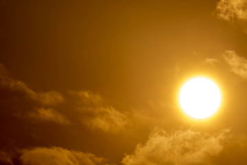 Brilliant orange sunrise over clouds in Asia with bright yellow sun on a cool sunny morning