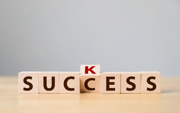 Wooden cube block flip over with word suck to success. Concept of successful in business
