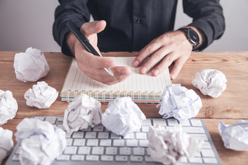 Man working in office. Crumpled paper balls on the table