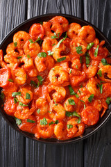 Fried shrimp in tomato sauce close-up in a plate. Vertical top view