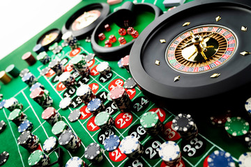 Casino theme, close up of roulette, red and black numbers, Stack of chips as background.