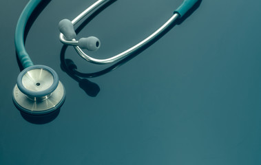 Closeup green stethoscope on doctor table or nurse desk. Health checkup or health insurance...