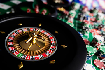Casino theme, close up of roulette, red and black numbers, Stack of chips as background.
