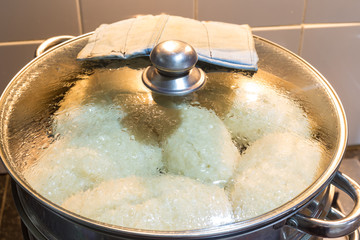 Juicy korean manti on a gas stove in a double boiler. Cooking delicious dishes, national Korean cuisine