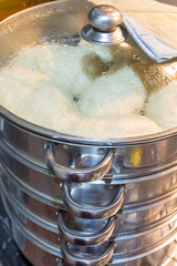 Juicy korean manti on a gas stove in a double boiler. Cooking delicious dishes, national Korean cuisine