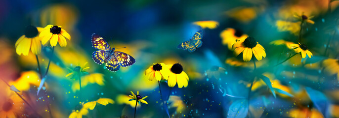 Fototapeta na wymiar Tropical butterflies and yellow bright summer flowers on a background of colorful foliage in a fairy garden. Macro artistic image. Banner format.