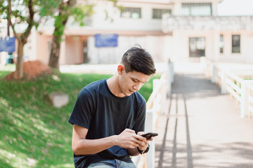 Asian Man Using Smart Phone At park 
