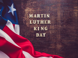 Wooden unpainted letters of the alphabet on a dark background. Martin Luther King Jr. Day. Top view, close-up. National holiday concept