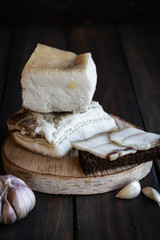 Salted pork lard on a dark wooden background.