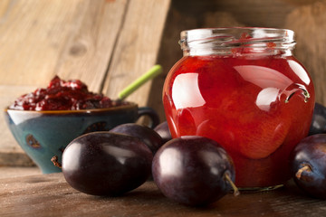 Preservation of freshly picked plums on a rustic wooden background
