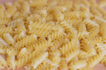 Scattered macaroni on a wooden surface close-up. Food background