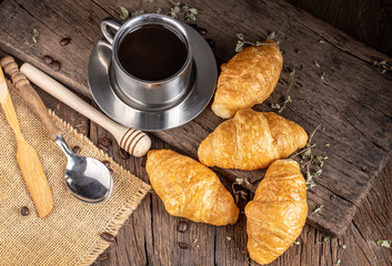 Coffee and croissants on the  wooden background, top view