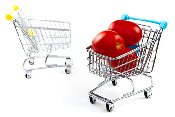 A tomato in shopping cart isolated on white background. Ripe tasty red tomatos in shopping cart. Tomato trading concept. Online shopping concept. Cart and tomato over a white background. business