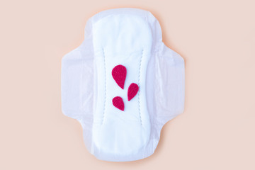 Protective menstrual pad with fabric blood drops on orange background. The concept of women gynecological health and intimate hygiene. Flat lay, copy space for text, close up