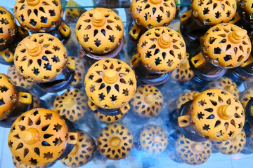 Arab lamps for candles on a glass table. Clay vessels for candles in the bazaar shop.