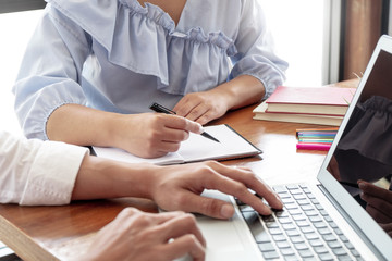 Group of College students working together with school assignment.