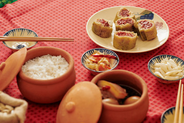 Pots and plates with various delicious food cooked for traditional Lunar Year celebration dinner