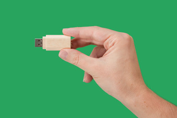 Wood USB memory stick on hand with green background
