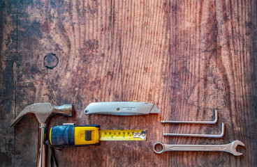  Top down view of various DIY tools on a wooden background with copy space above