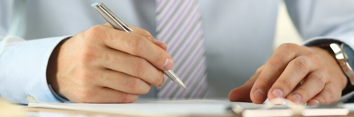 Male arm in suit and tie hold silver