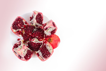 Top view of splitted pomegranate fruit on the white dish
