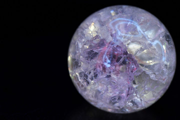 Glowing crystal ball with cracks inside on a dark background. The process of predicting the future