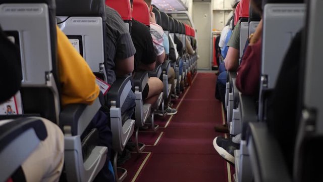 Passengers are sitting inside the plane. Aircraft cabin. People travels