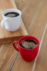 Two red and white mug coffee on wooden